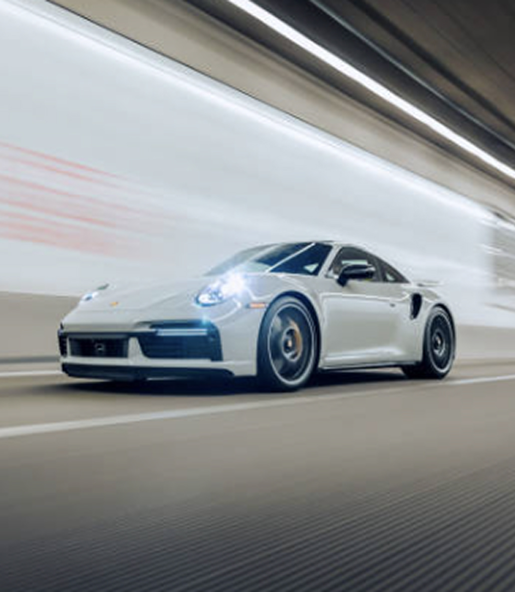 Witte sportauto rijdt door een tunnel